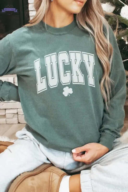 Woman wearing a green Lucky St Patrick's Day long sleeve shirt, styled casually for a festive look.