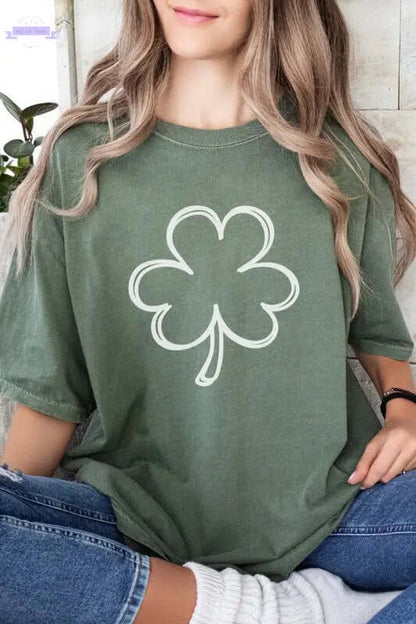 Woman wearing a green long sleeve shirt with a white shamrock graphic, perfect for St. Patrick's Day celebrations.