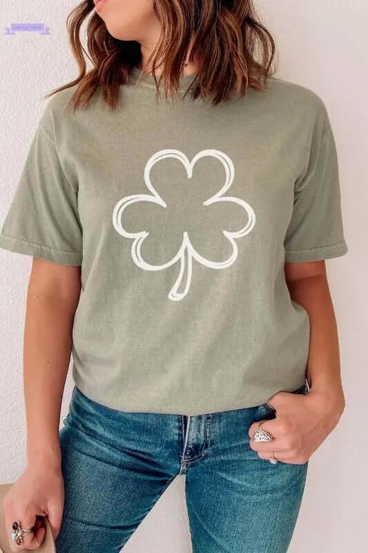 Woman wearing a green Shamrock St Patrick's Day Clover shirt with long sleeves, showcasing a white clover graphic design.